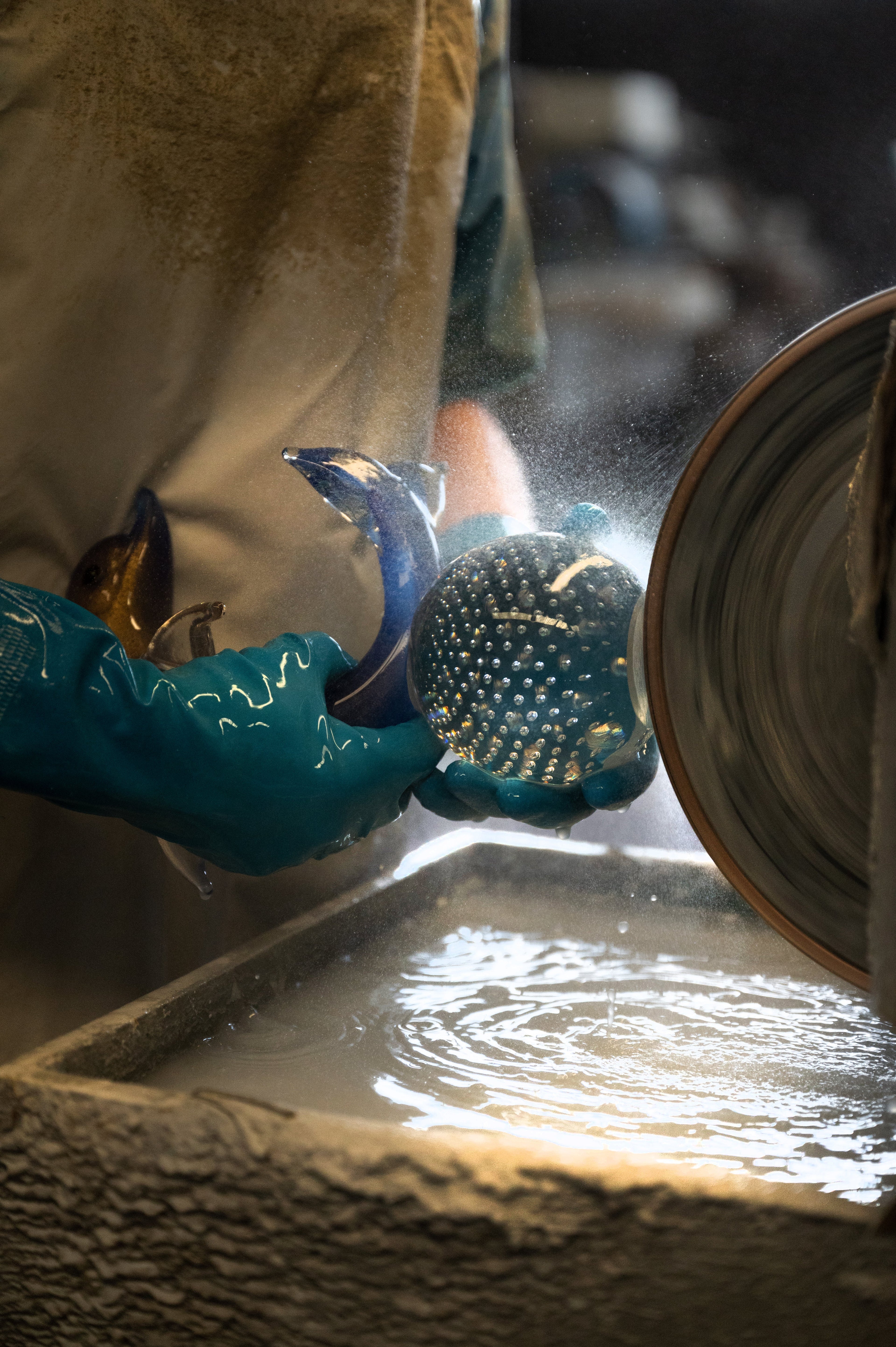 Duccio Di Segna artisan grinding a blue and amber crystal piece in the Tuscan atelier