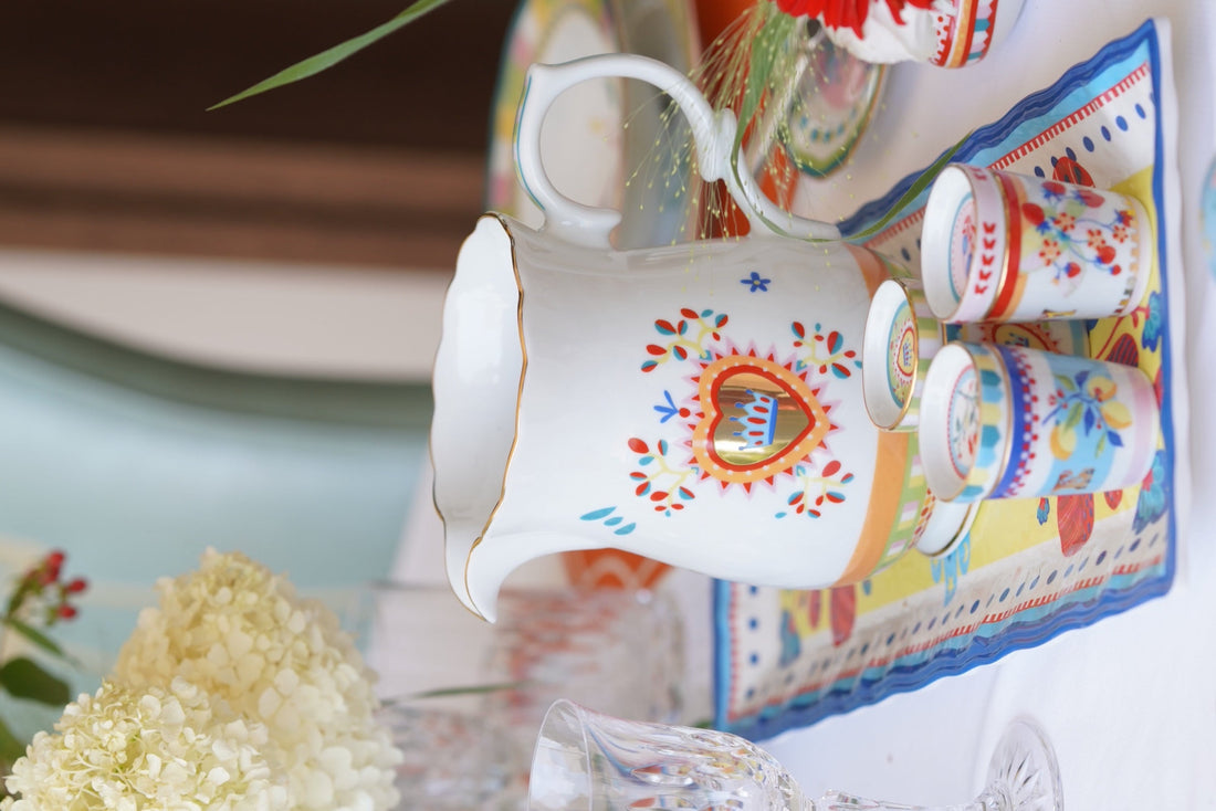 Mamma Mia porcelain pitcher and small espresso cups with gold details on a patterned Sicilian-print tray