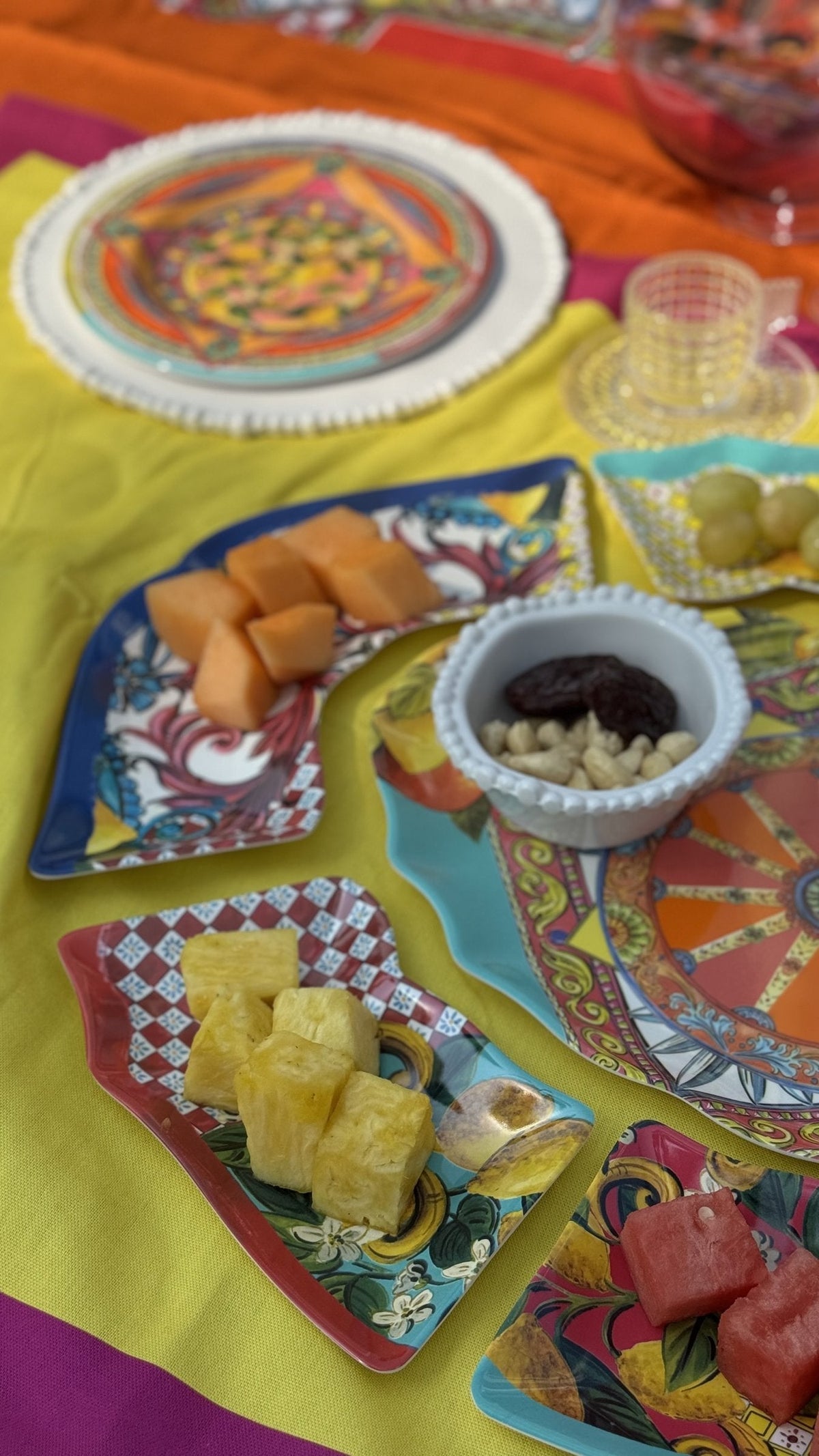 Bright Italian melamine plates with fruit snacks laid out on a colourful party table