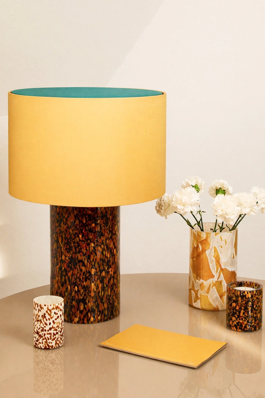 Stories of Italy Leopardo pillar lamp lit on a console beside a matching Murano glass vase
