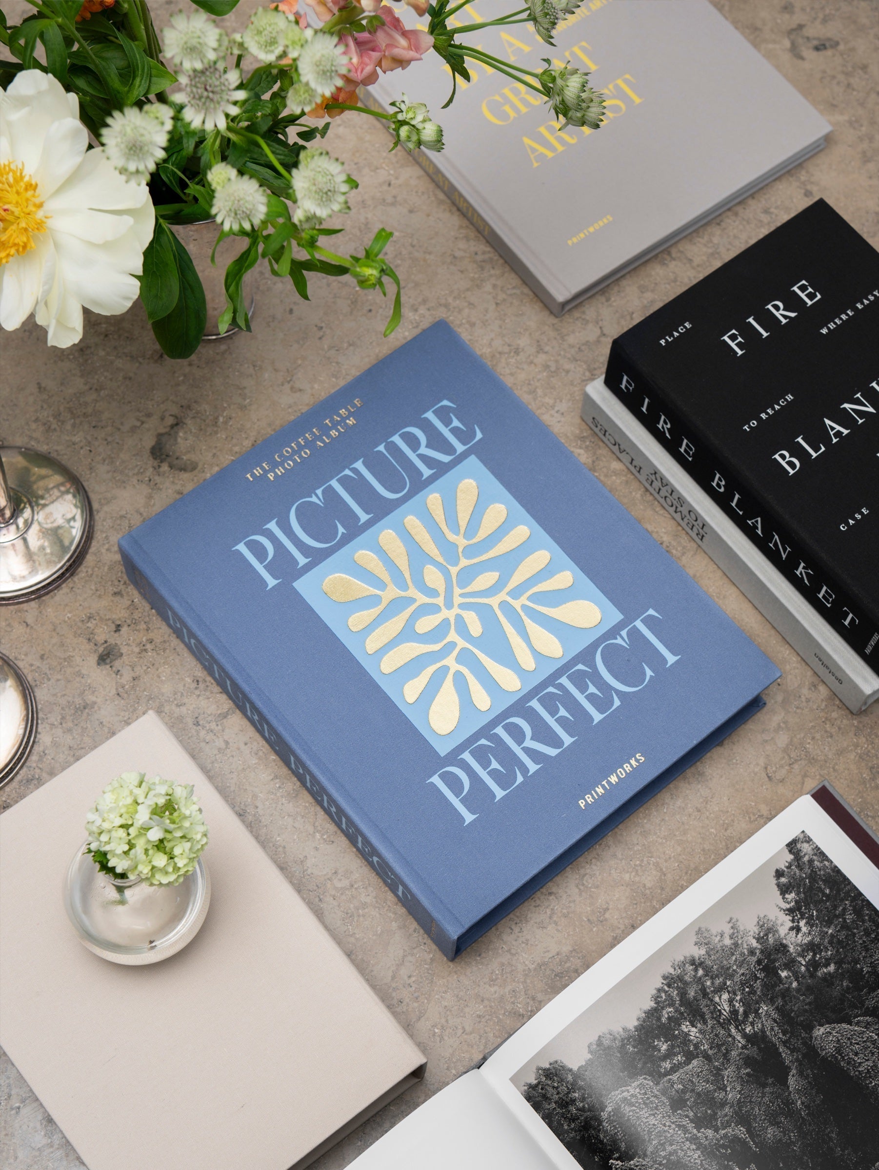 Printworks Picture Perfect photo album styled on a table among flowers and design books