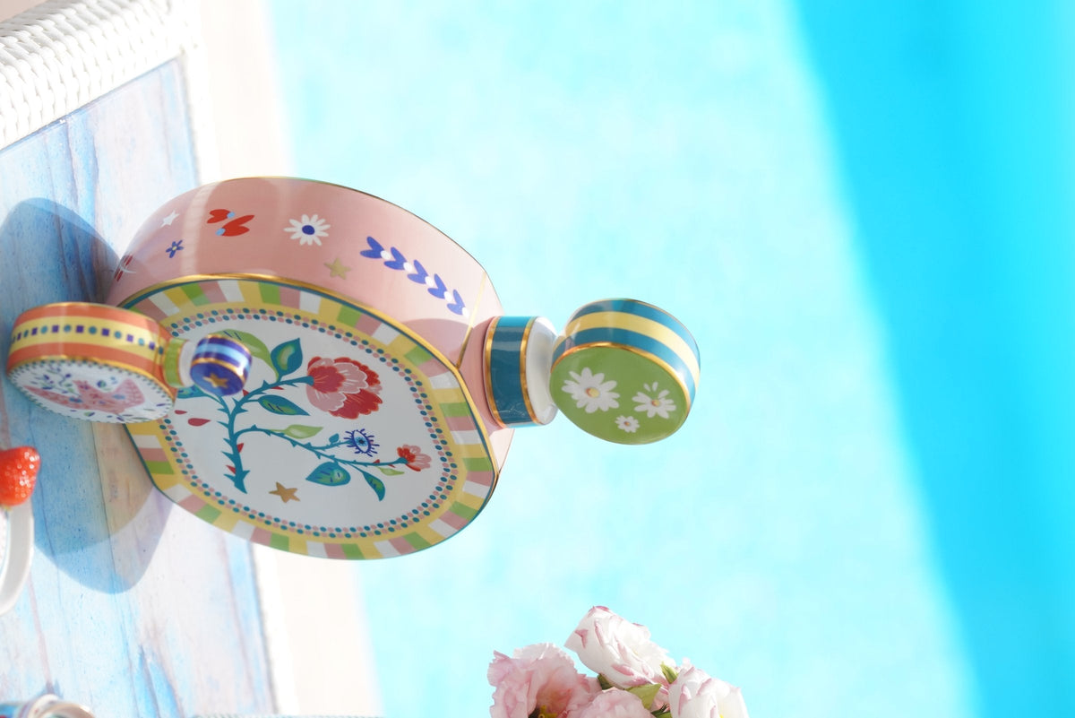 Sculptural hand-painted Italian tableware piece in vivid colour against a bright pool backdrop