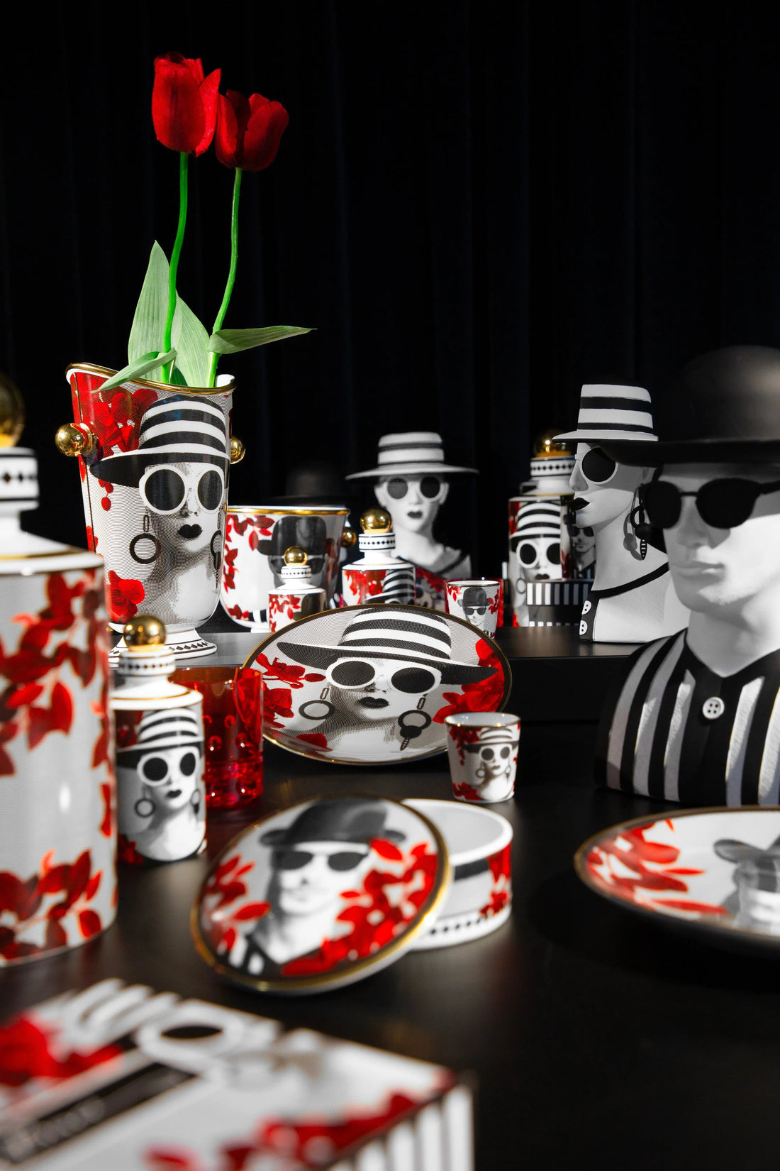 Gli Inseparabili collection — black-and-white face motif tableware with red petals and gold accents by Amprio Milano