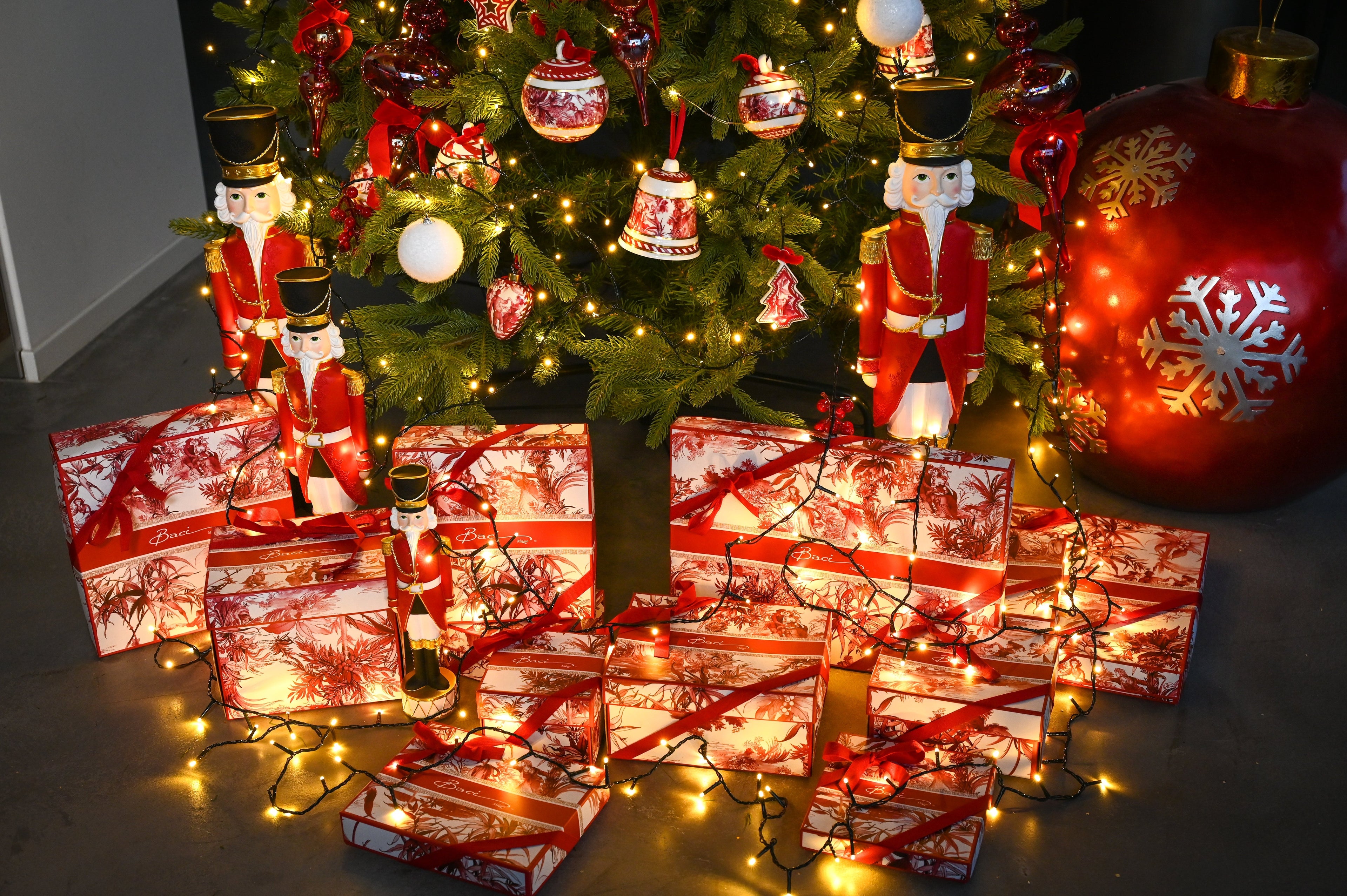 Le Rouge Christmas display — red toile gift boxes, nutcracker figures and tree ornaments by Amprio Milano