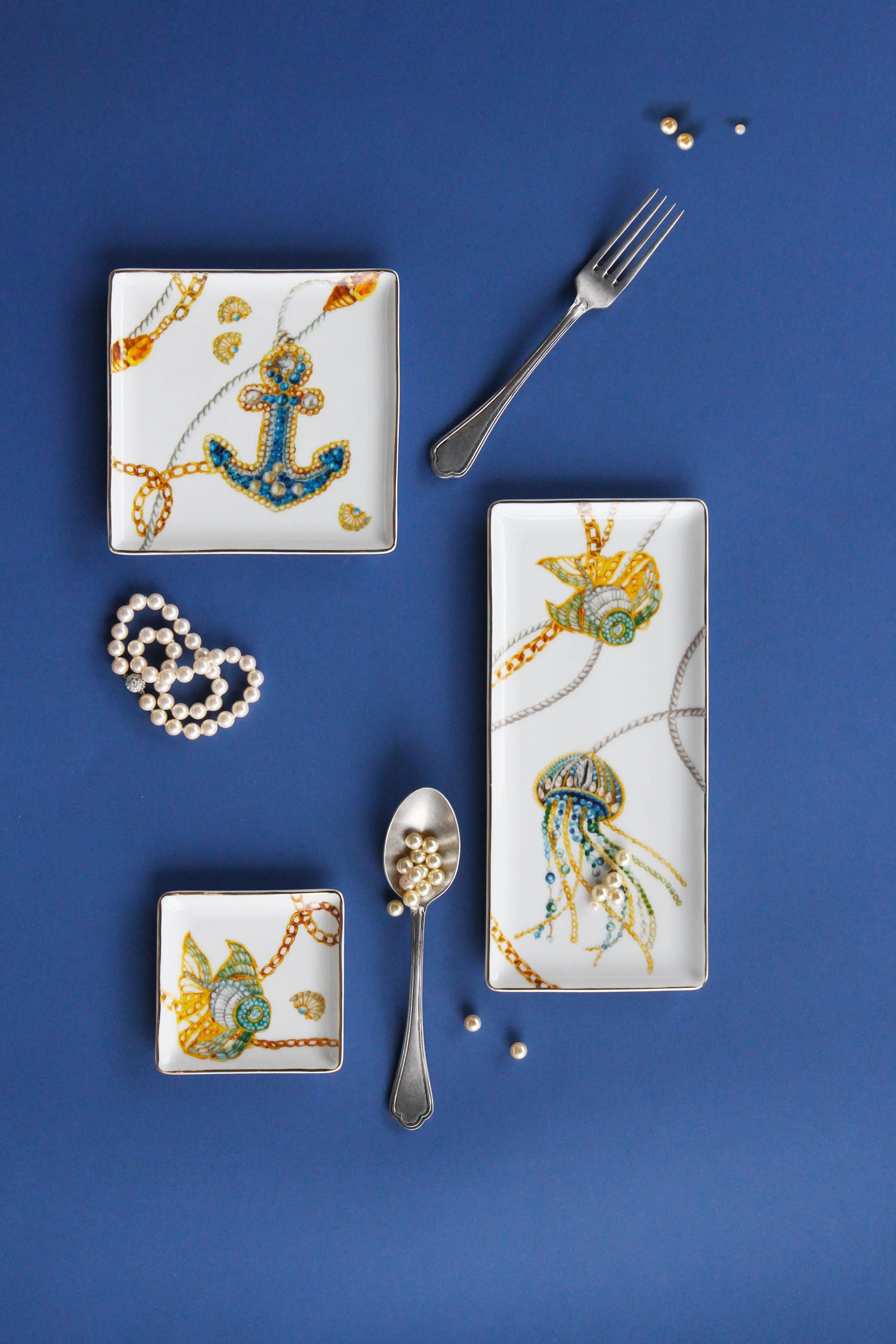 Portofino trays — rectangular and square porcelain with jeweled nautical motifs (anchor, shell, jellyfish) by Amprio Milano