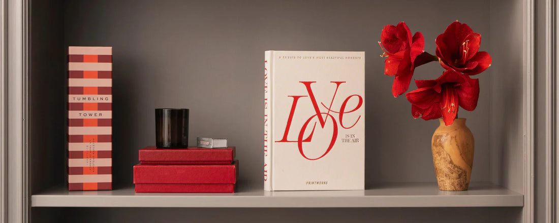 Printworks Tumbling Tower box with red books and red flowers on a grey shelf — Amprio Milano.